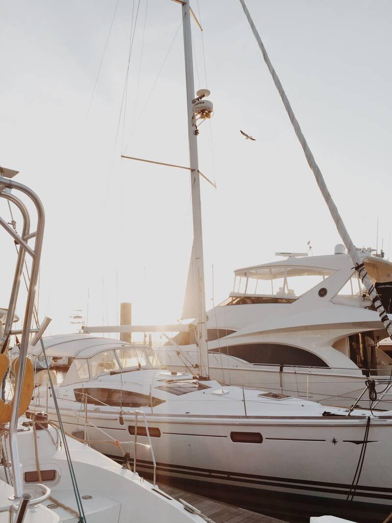 Sailboat docked in a marina between other boats