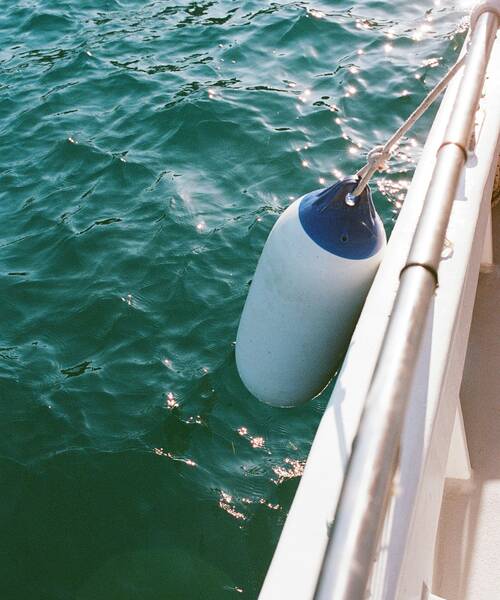 Boat fender tied to the railing.