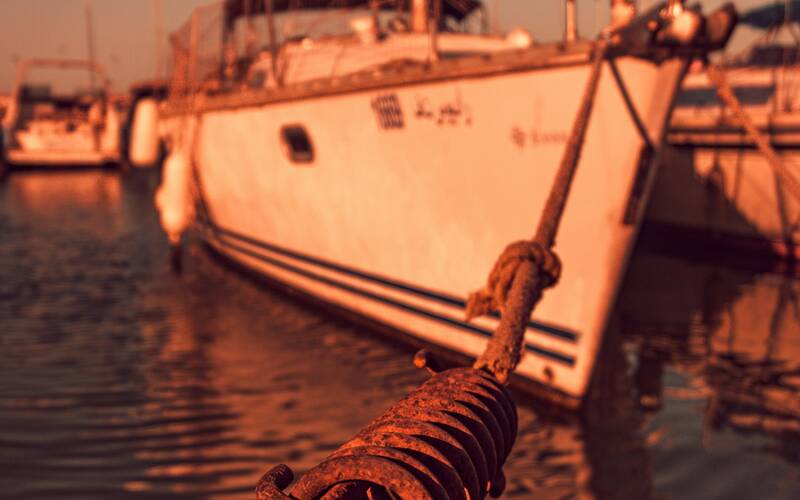 Mooring line snubber attached to a dock line of a moored sailboat in a marina.